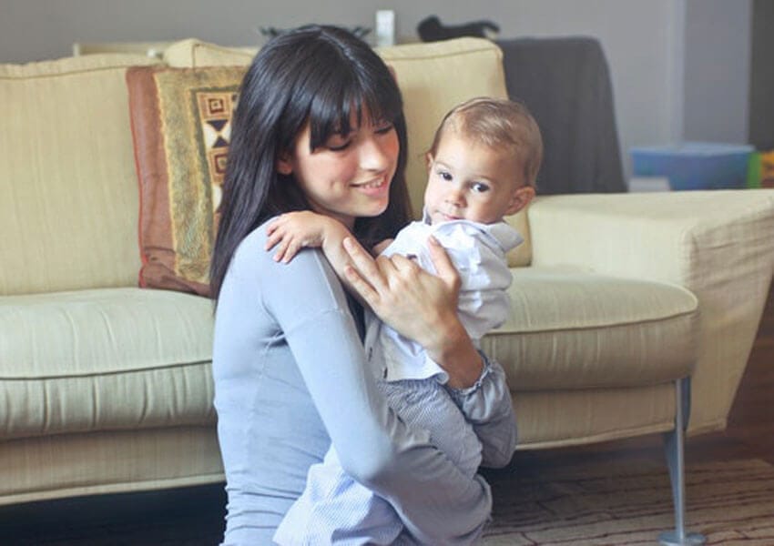 A woman carrying a baby.